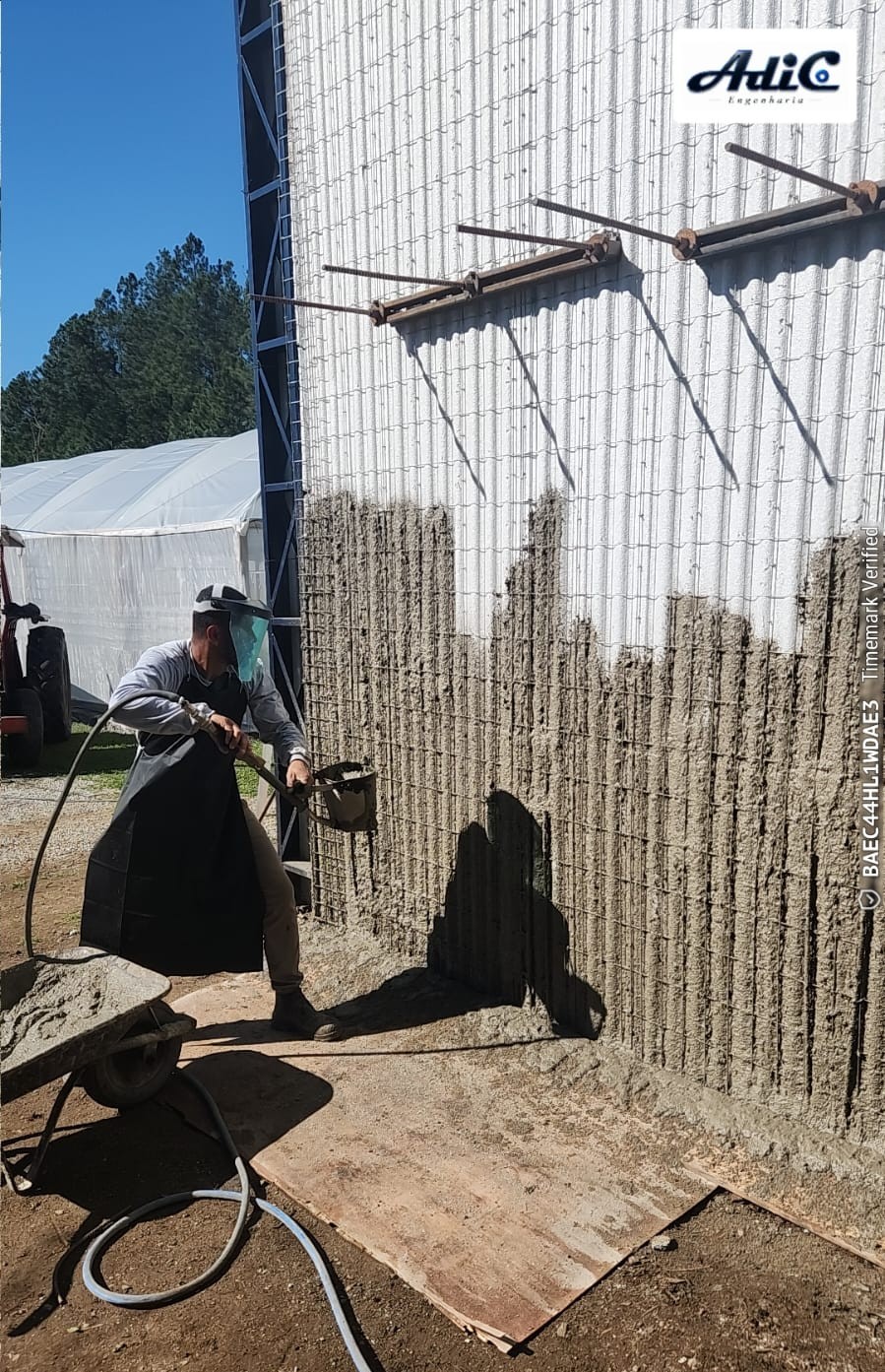 Profissional aplicando argamassa estrutural sobre painel monolítico em EPS.